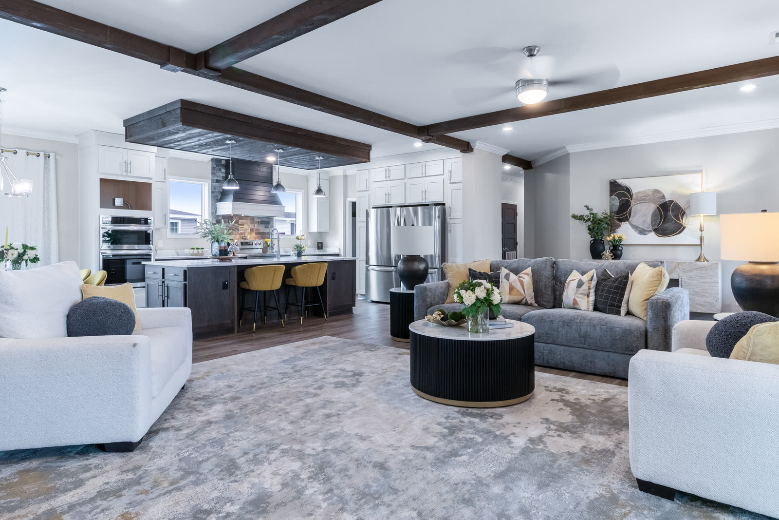 Open living room and kitchen under wood ceiling beams