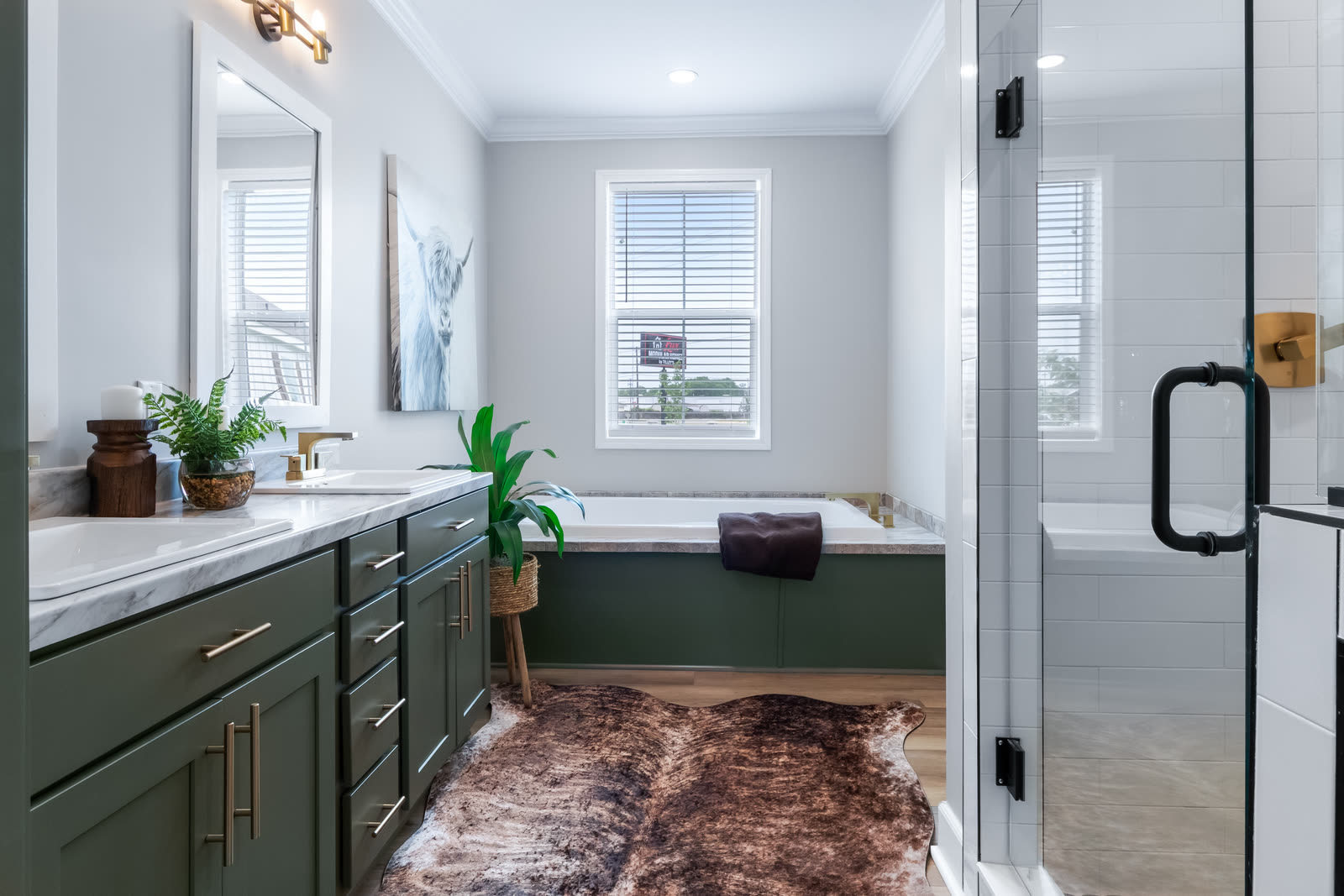 Primary bath with a green vanity and glass shower